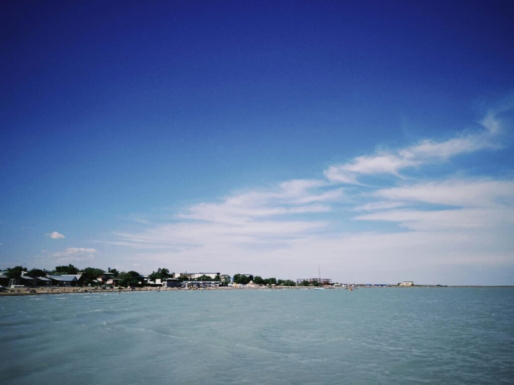 Scenic view of Lake Balkhash in Kazakhstan with a vibrant blue sky and distant shoreline.